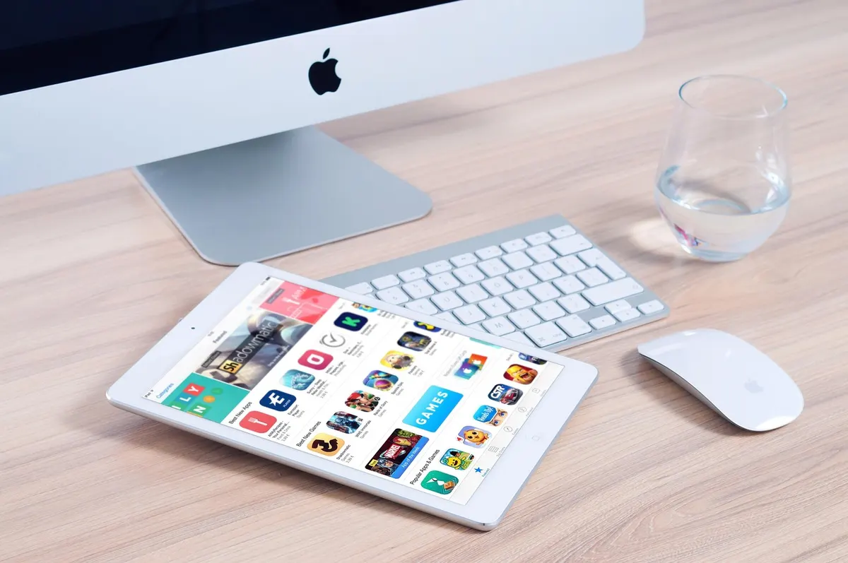iMac, keyboard and iPad displaying the App Store for iOS app development