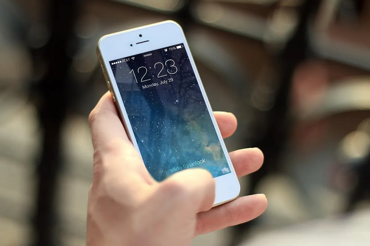 iOS App Security Hand holding an iPhone showing the lock screen for iOS app security