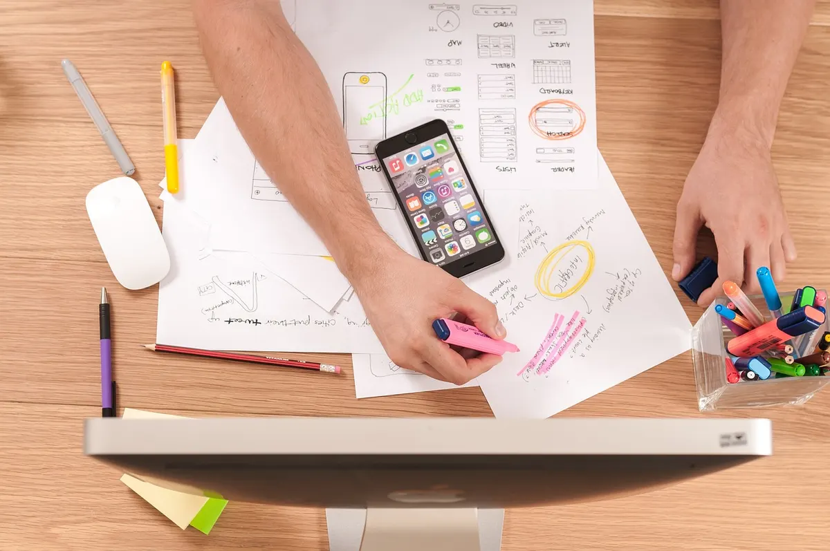 Modern Web Design Trends Designer sketching UI wireframes and mobile app mockups on paper