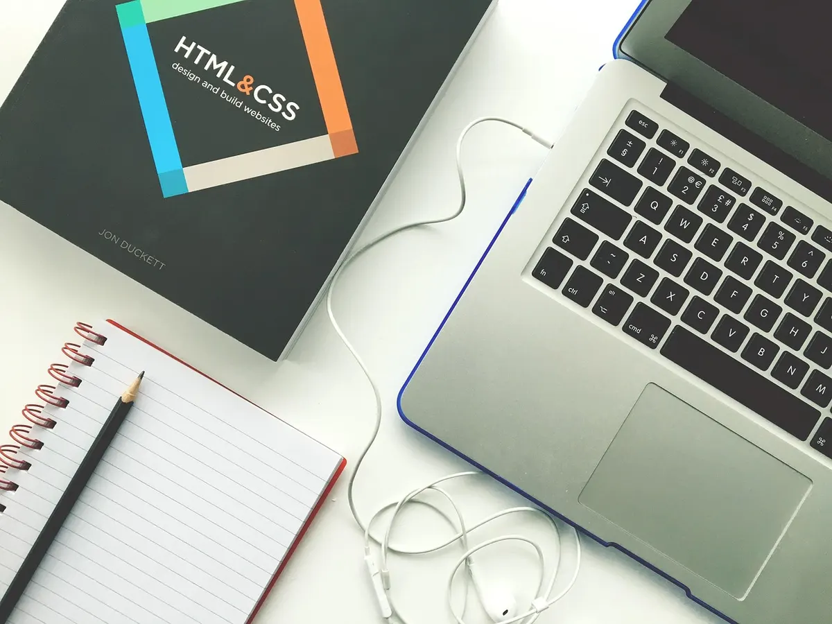 Laptop and HTML and CSS design book on a designer's desk for professional web design