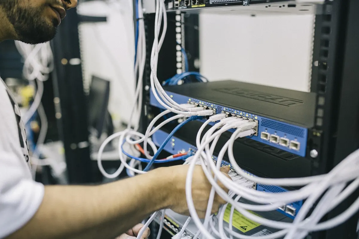 Network engineer configuring server rack cabling for SQL Server indexing