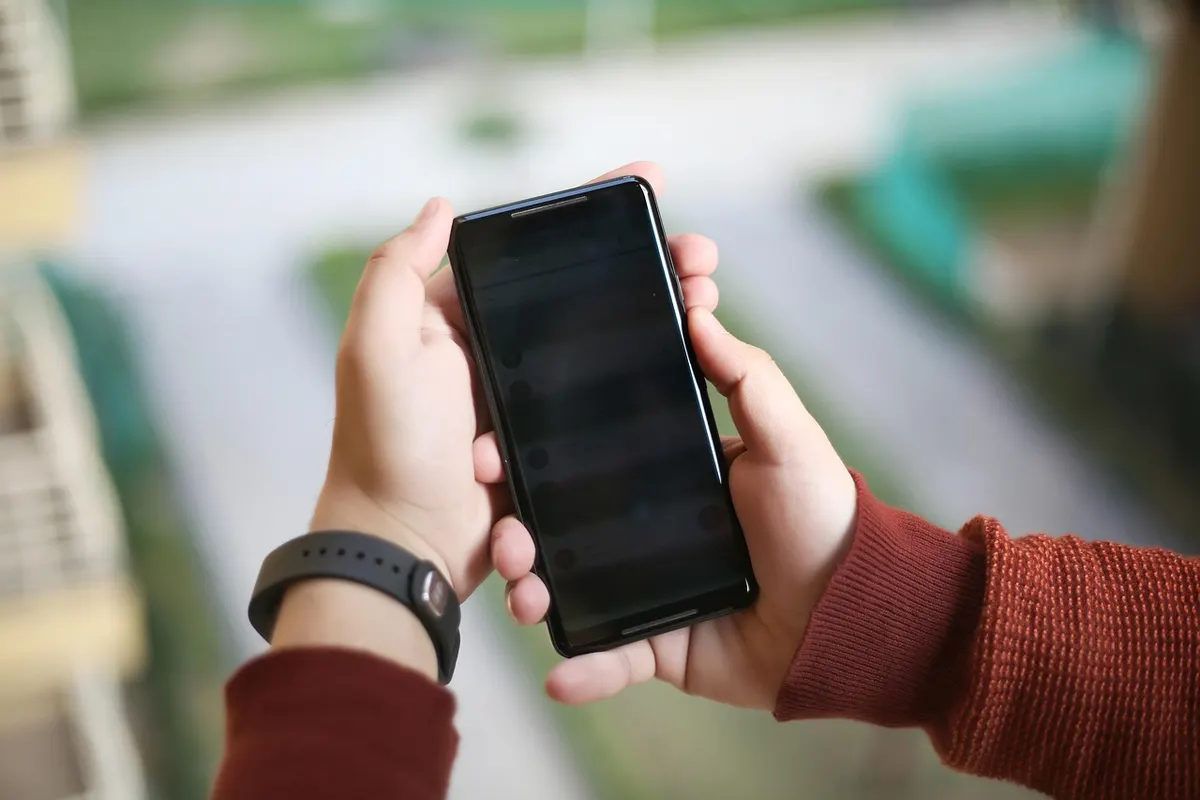 Hands holding and testing a smartphone for Android app development