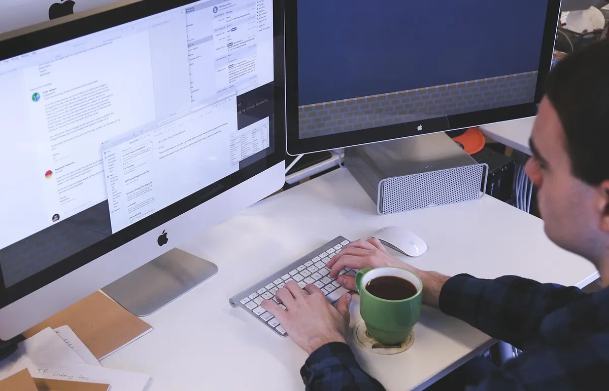 Web Development Web developer coding on dual monitors at a professional workstation